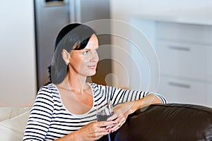 Beautiful young woman holding glass with red wine