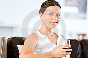 Beautiful young woman holding glass with red wine