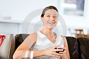 Beautiful young woman holding glass with red wine