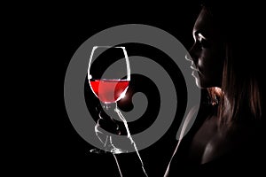 Beautiful young woman holding the glass of a red wine