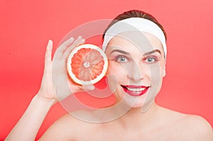 Beautiful young woman holding grapefruit