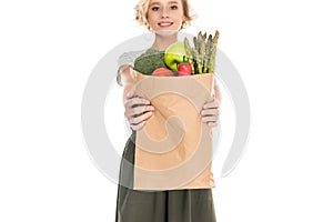 beautiful young woman holding grocery bag and smiling at camera
