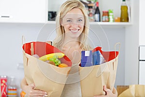 Beautiful young woman holding grocery shopping bags