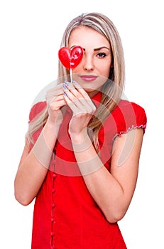 Beautiful young woman holding heart shape lollipop on white