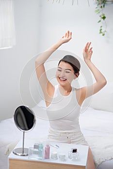 Beautiful young woman holding her arms up and showing clean underarms