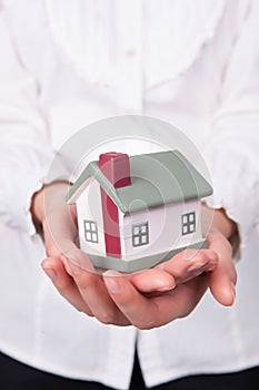 Beautiful young woman holding house model