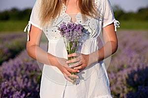 Hermoso mujer joven posesión lavanda en sobre el atardecer 