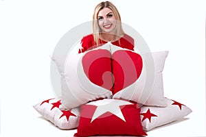 Beautiful young woman holding a pillow with the heart. Beautiful pillows to decorate the interior of the house. Pillow with star o