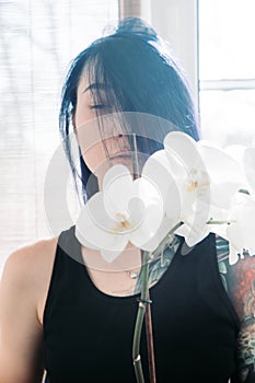 Beautiful young woman holding potted plant and smiling at camera isolated