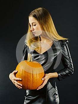 Beautiful young woman holding pumpkin for Halloween