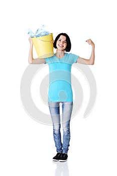 Beautiful young woman holding recycling bin