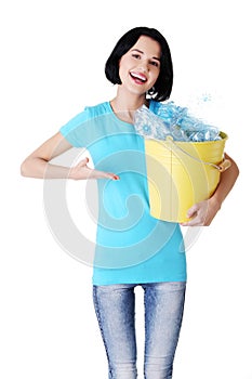 Beautiful young woman holding recycling bin