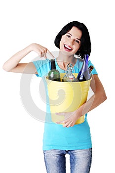Beautiful young woman holding recycling bin