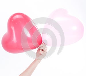 Beautiful young woman holding red balloon heart.