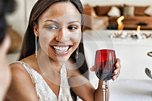 Beautiful young woman holding red wine glass at home