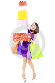 Beautiful young woman holding shopping bag and gift boxes