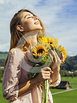 Beautiful young woman holding sunflowers