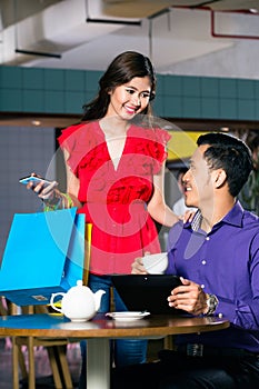 Beautiful young woman holding three shopping paper bags