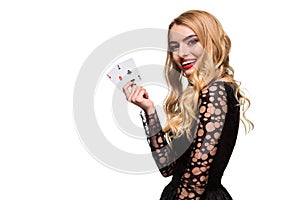 Beautiful young woman holding two ace of cards in her hand isolated on black background