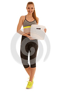 Beautiful young woman holds a scale as she lost weight isolated