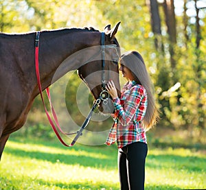 Beautiful young woman with a horse outdoor