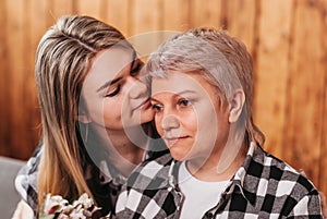 Beautiful young woman hugs her mother. Close-up portrait