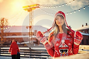 Beautiful young woman on the ice rink, smiling in the sun