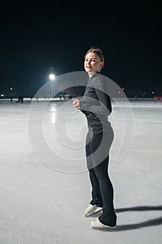 Beautiful young woman ice skating and performing short program