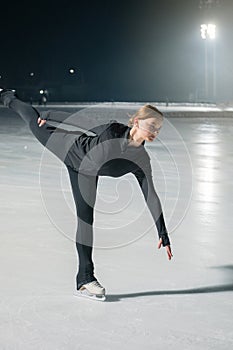 Beautiful young woman ice skating and performing short program