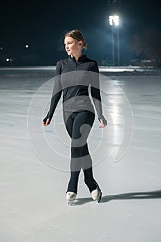 Beautiful young woman ice skating and performing short program