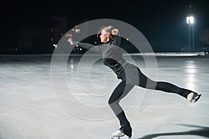 Beautiful young woman ice skating and performing short program