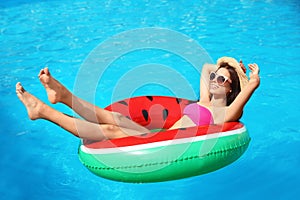 Beautiful young woman with inflatable ring in pool