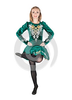 Beautiful young woman in Irish dance green dress jumping isolate