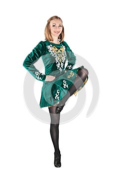 Beautiful young woman in Irish dance green dress jumping isolate