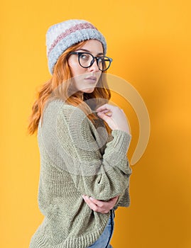 Beautiful young woman, isolated on yellow background. Pretty girl posing. Attractive female looking to camera