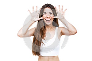 Beautiful young woman joking and making funny face over white background.