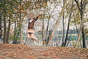 Beautiful young woman jumping in a city park