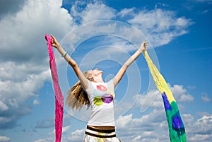 Beautiful young woman jumping on field in summer