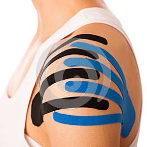 Beautiful young woman with kinesiotape on her shoulder to mobili photo