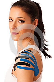 Beautiful young woman with kinesiotape on her shoulder to mobili photo