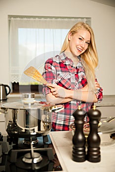 Beautiful young woman in kitchen cooks a delicious meal