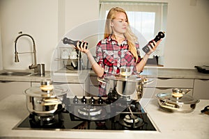Beautiful young woman in kitchen cooks a delicious meal uncertain which spice to use