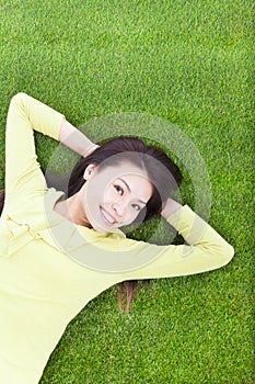 Beautiful young woman laying down in park