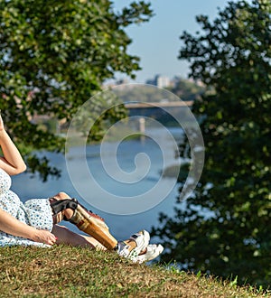 Beautiful young woman leg amputee in a dress walking in park at sunny day
