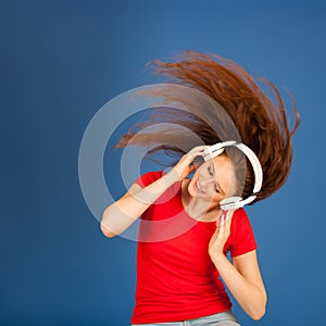 Beautiful young woman listen to the music and dance over vibrant