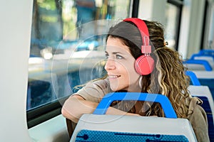 Beautiful young woman listening to music in a train