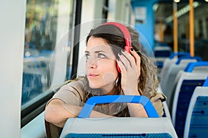 Beautiful young woman listening to music in a train