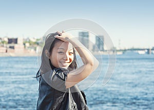 Beautiful young woman with long black hair smiling in the city