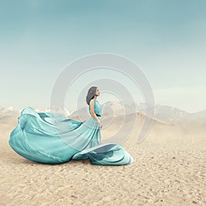 Beautiful young woman in long fluttering dress posing outdoor