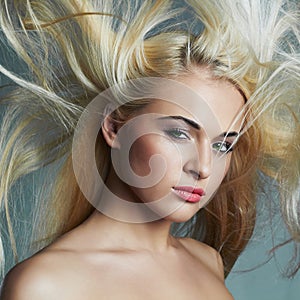 Beautiful young woman with long hair on blue background.Blond girl.hairstyle. Beauty salon